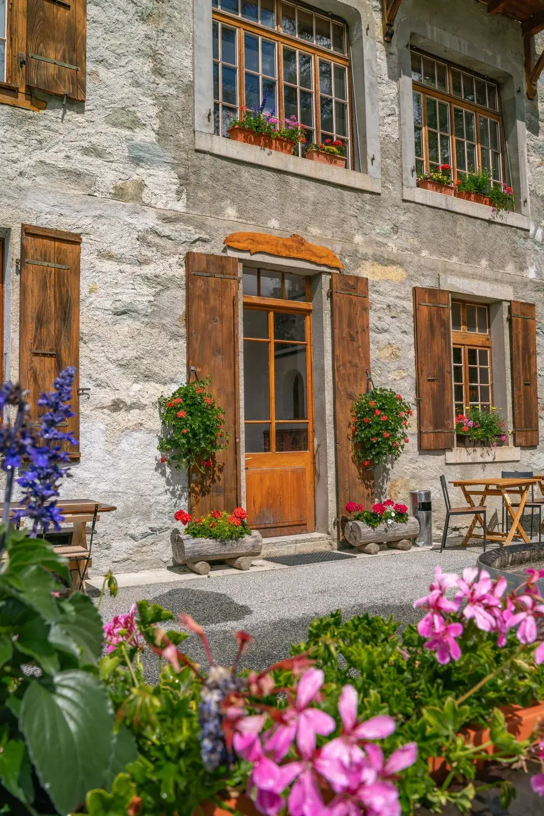 Entrée fleurie du Grand Hôtel & Kurhaus, porte de bois et géraniums — Arolla
