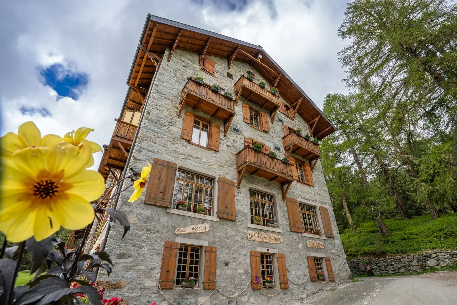 Façade of the Grand Hôtel & Kurhaus framed by mountain flowers, Arolla