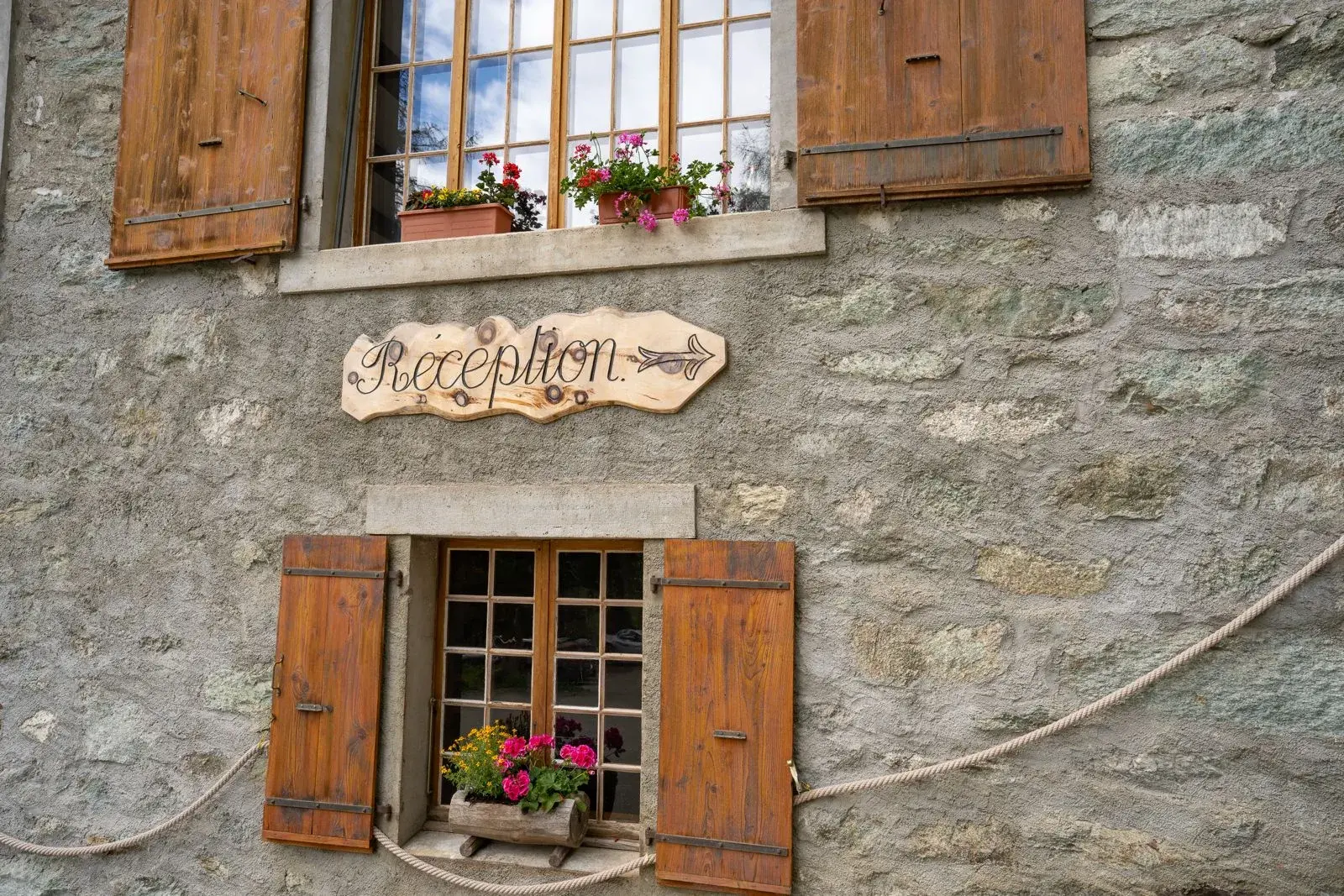 Hand-painted “Réception” sign on the stone façade of the Grand Hôtel & Kurhaus — Arolla