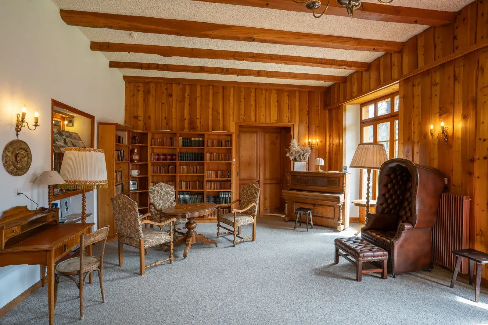 La bibliothèque historique de l'hôtel, ses rayonnages et son piano